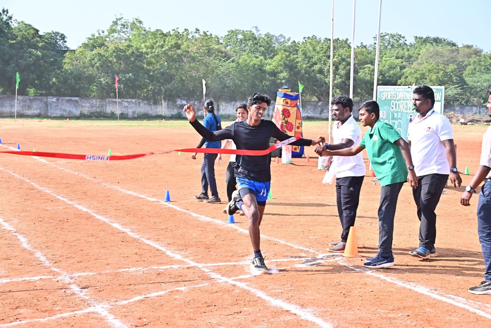 A student breaking the finish-line tape at a Sportsa Sports Day