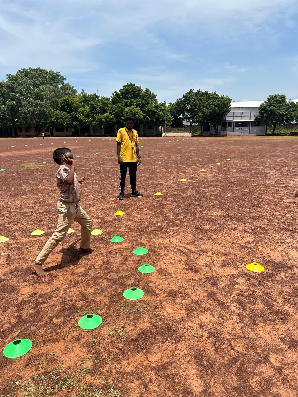 A student practising an agility and throwing drill with an SIO coach