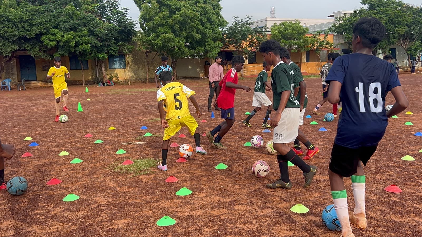 Older students in a football drill on a school ground, part of SIO's expanding programme